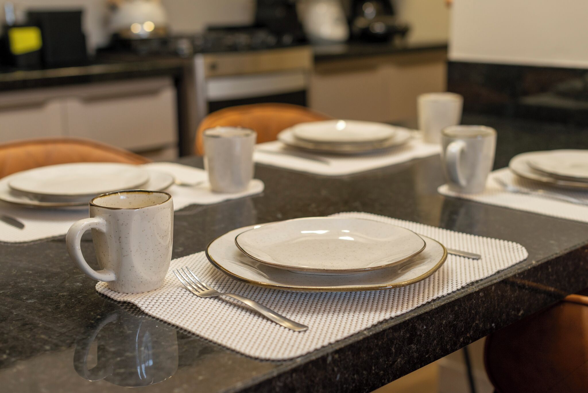 Una mesa de comedor puesta con platos, una taza y cubiertos.