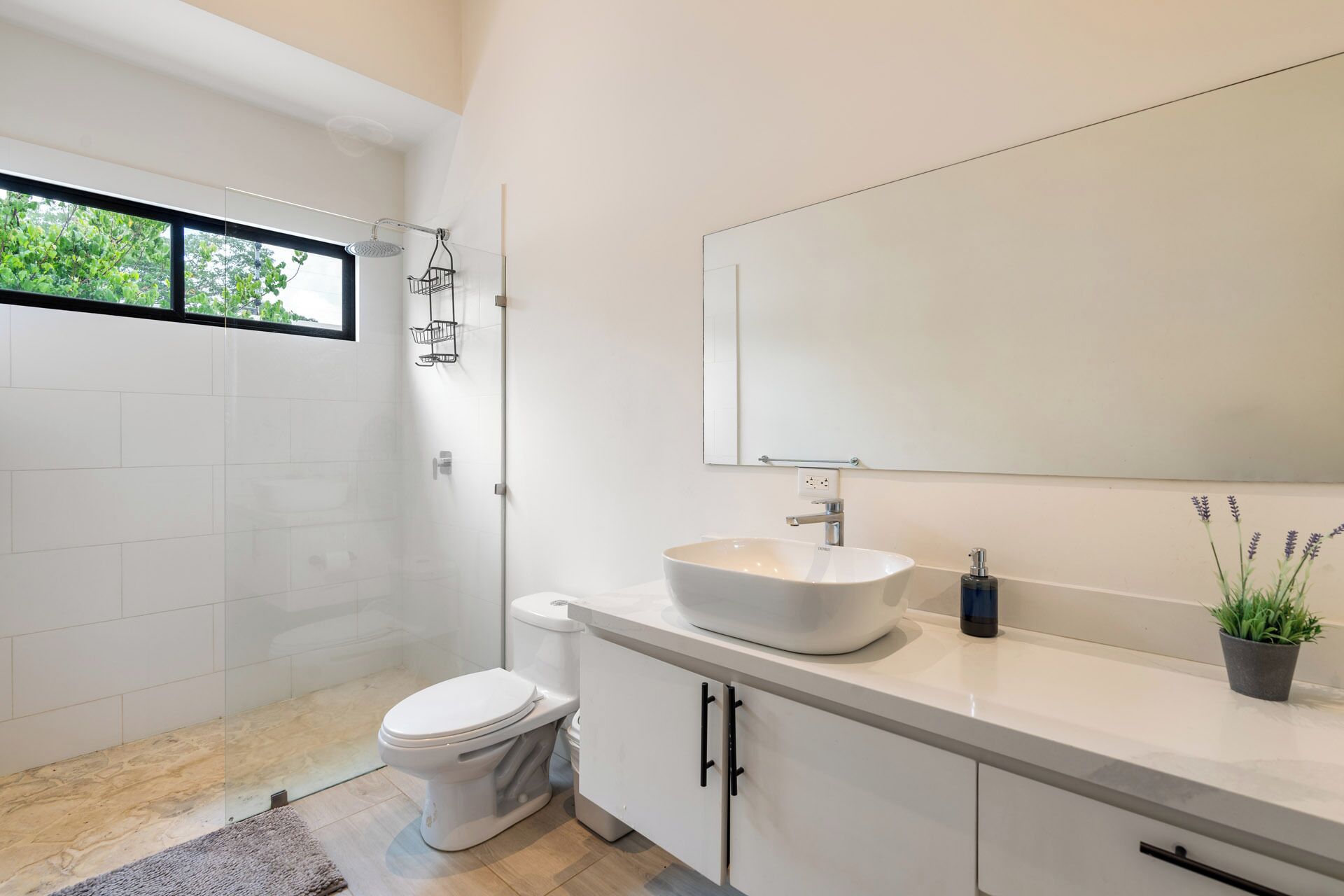 A modern bathroom with a toilet, sink, and shower.