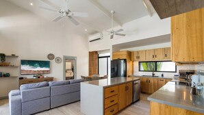 Une cuisine moderne avec des meubles en bois, un îlot central et un four encastré.