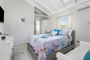 A bedroom with a bed, a desk, a chair, and a window with blinds.