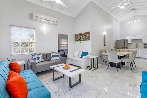 A modern living room with a sofa, coffee table, and dining area.