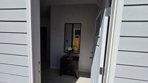 A hallway with a dark wooden console table and a mirror. - One bedroom house (Portland)