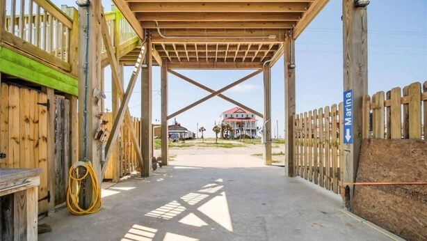 A construction site with a wooden structure, a yellow hose, and a sign indicating 'Marina'. - Charming Studio house with WiFi & AC in brilliant Holly Beach, La (Cameron)