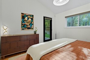 A bedroom with a bed, a dresser, a window, and a door. - Luxury Scandinavian nature escape, private saun (Springfield)