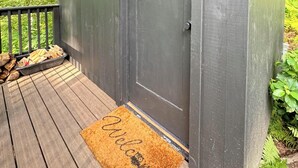 A dark wooden door with a doormat that reads "Welcome".