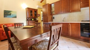 A kitchen with wooden cabinets, a dining table, and chairs. - Gorgeous home in Perdifumo with WiFi (Perdifumo)