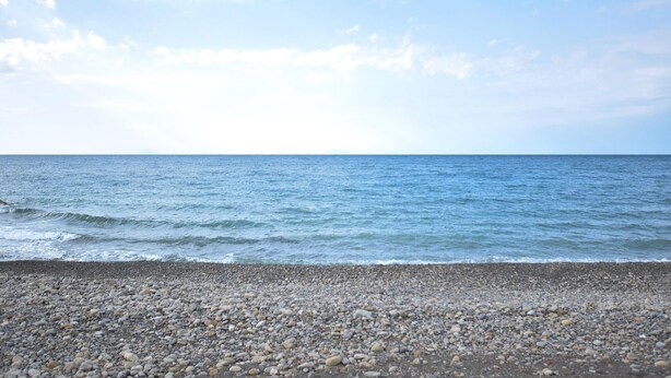 A pebbled beach with a view of the ocean under a partly cloudy sky. - 1 bedroom amazing apartment in Acquedolci (Acquedolci)
