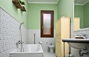 A bathroom with a bathtub, a sink, a bidet, and a cabinet. - Awesome apartment in Menfi with WiFi (Menfi)