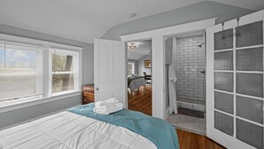 A bedroom with a bed, a door leading to a bathroom, and a view of another room. - Arcade Games, Pool Table, Huge Deck, Seasonal View (Davenport)