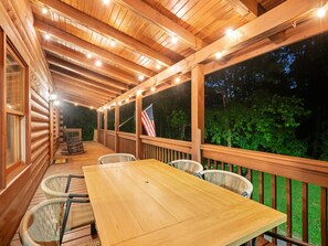 A covered outdoor area with a wooden deck, a table, and chairs. - Great Life At Grants Mountain Hot Tub-Fire Pit-WiFi-Fireplace (Marion)