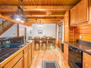 A wooden interior with a kitchen, dining area, and staircase. - Great Life At Grants Mountain Hot Tub-Fire Pit-WiFi-Fireplace (Marion)