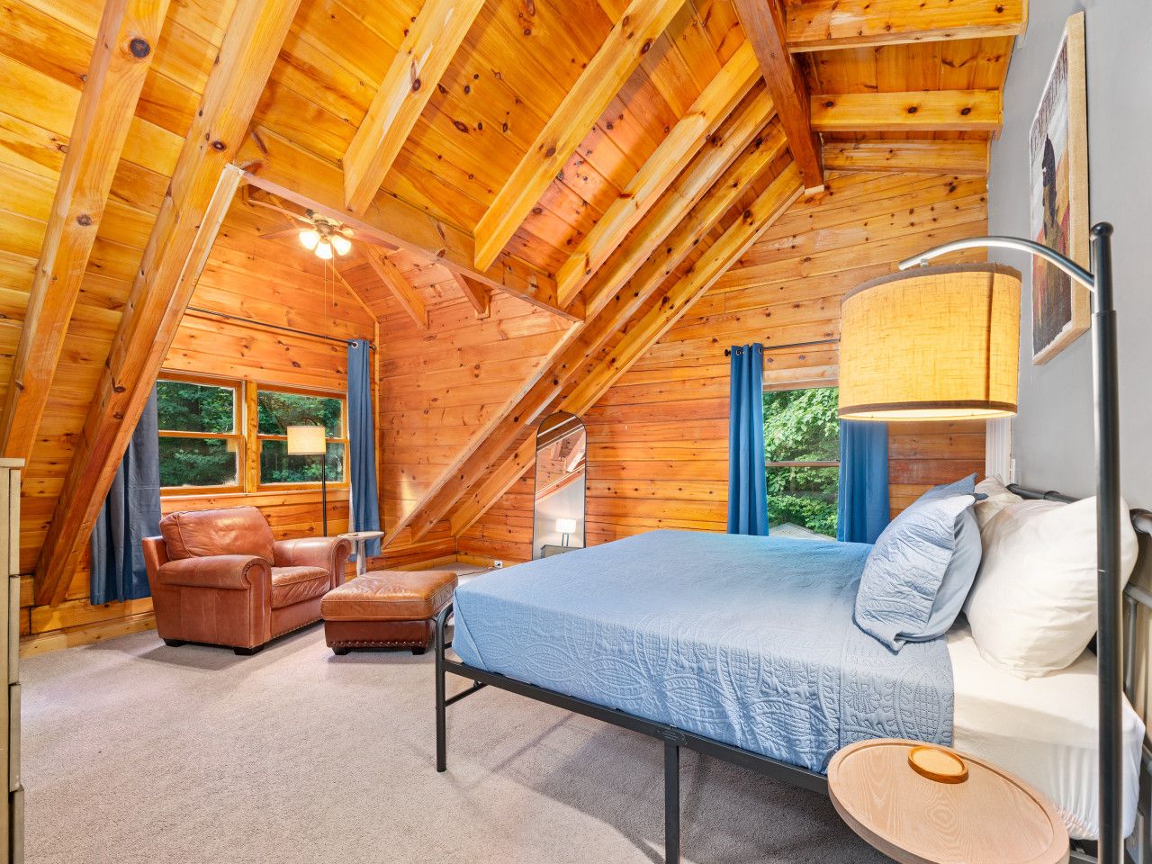 A cozy attic bedroom with a bed, a chair, and a small table.