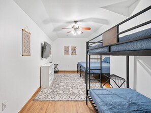 A dormitory room with bunk beds, a ceiling fan, a desk, and a TV. - Great Life At Grants Mountain Hot Tub-Fire Pit-WiFi-Fireplace (Marion)