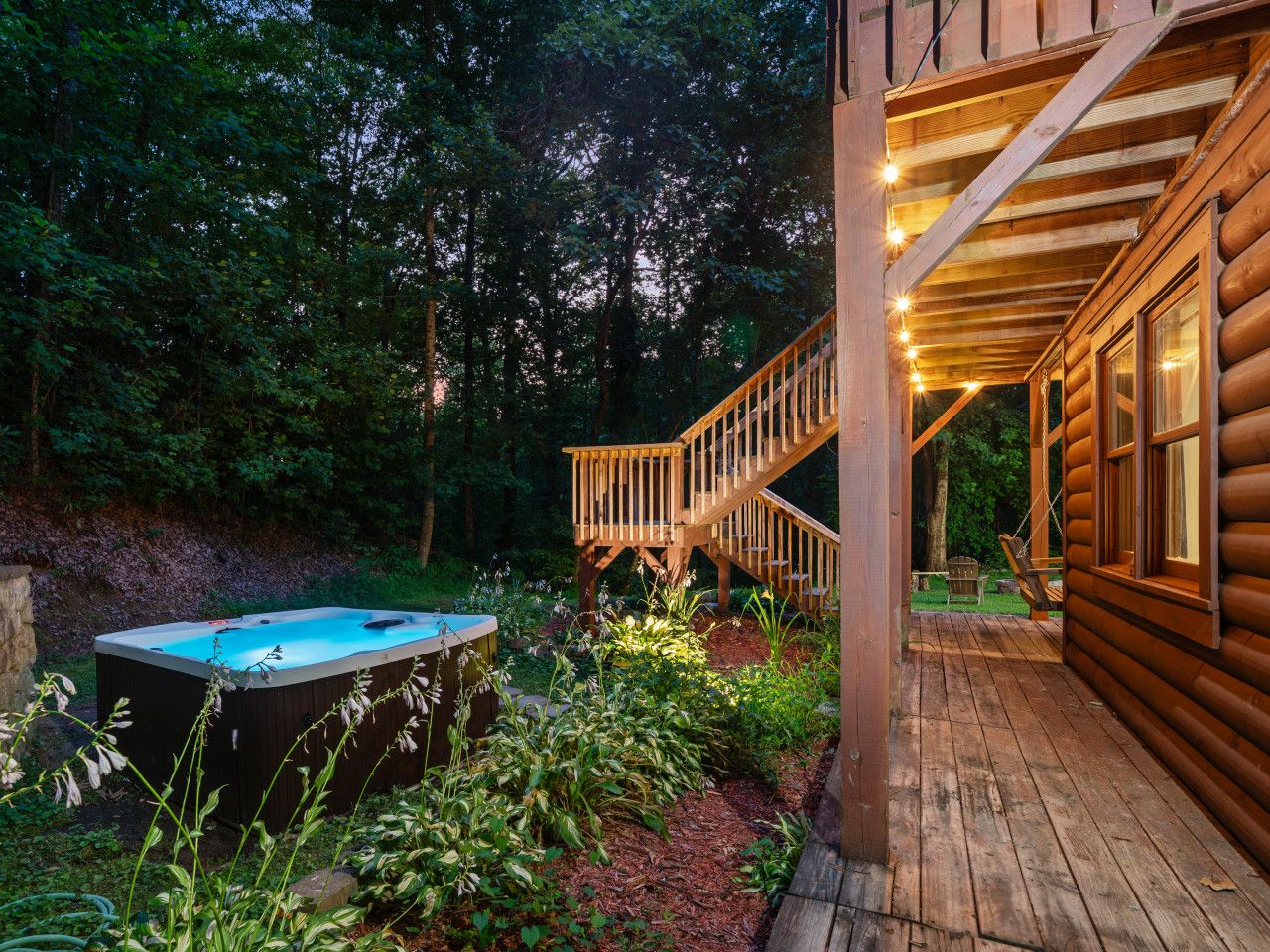 Una cabaña de madera con jacuzzi y terraza de madera.