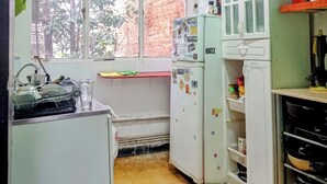 A small kitchen with a window, a sink, a refrigerator, and a stove. - Beer and Beer (Valparaíso)