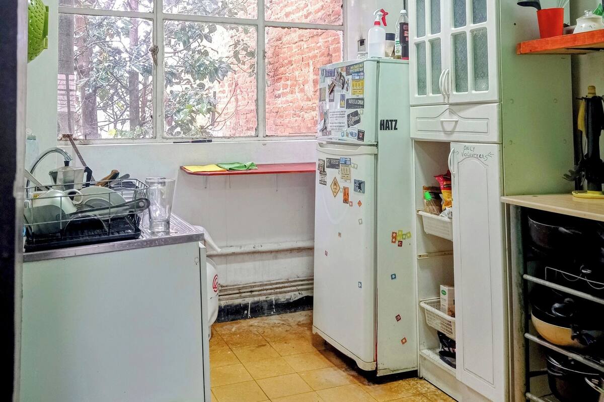 A small kitchen with a window, a sink, a refrigerator, and a stove.