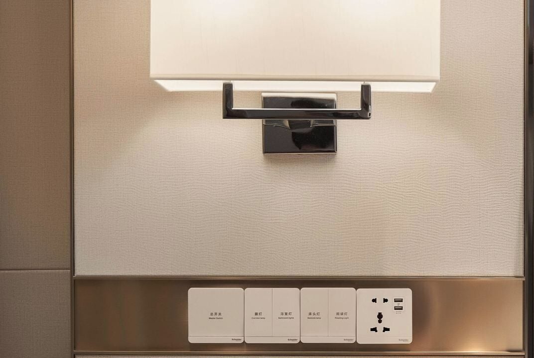 A modern elevator interior with a control panel featuring buttons for different floors and a power outlet.