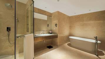 A modern bathroom with a glass-enclosed shower, a freestanding bathtub, and a vanity with a mirror and sink.