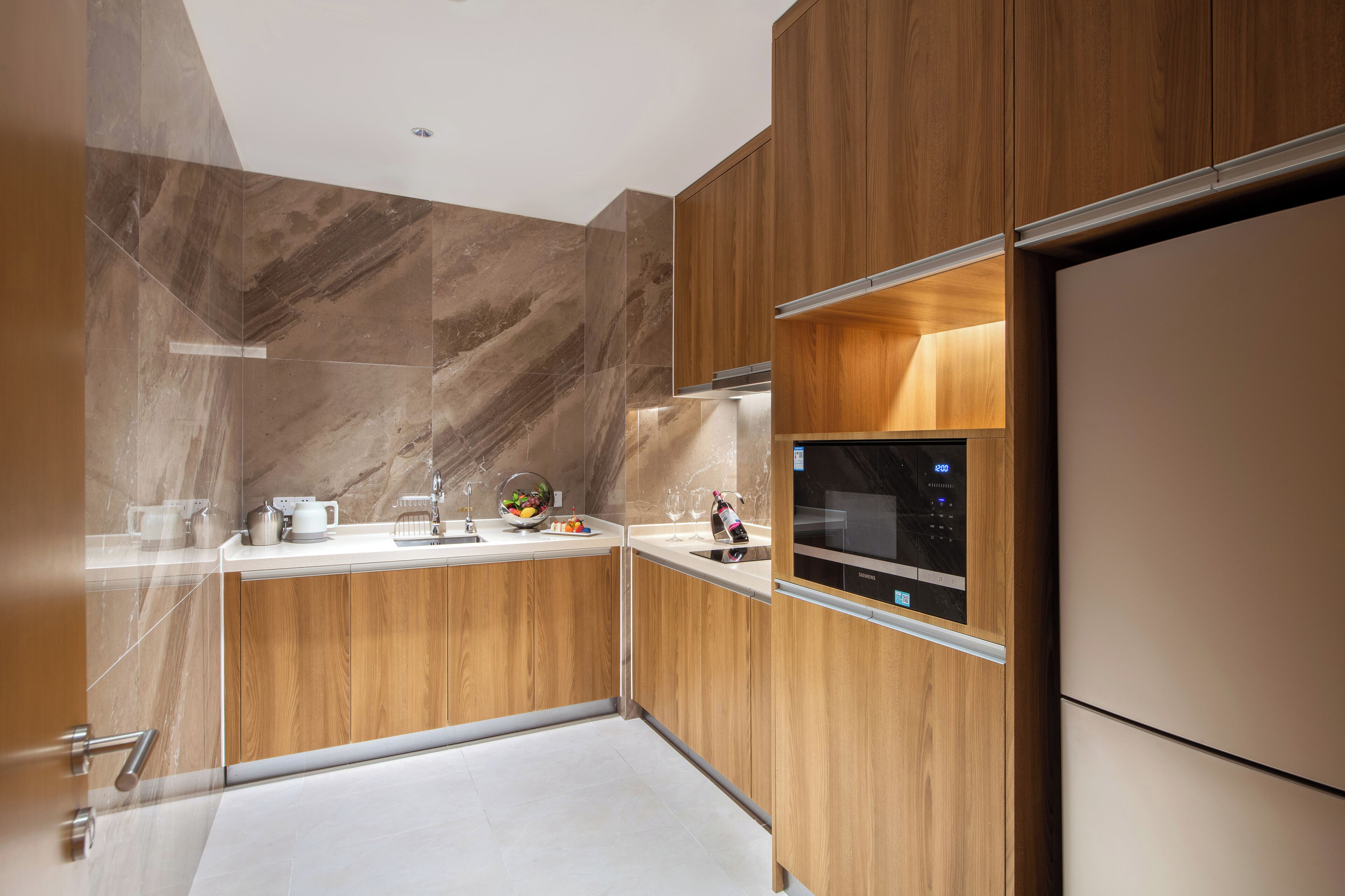A modern kitchen with wooden cabinets, a built-in microwave, and a stainless steel sink.