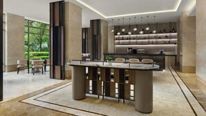 Una cocina moderna con una isla central, electrodomésticos integrados e iluminación colgante.