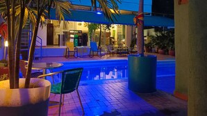 An outdoor pool area with lounge chairs and a covered seating area. - MAUKA OASIS Taganga  (Santa Marta)