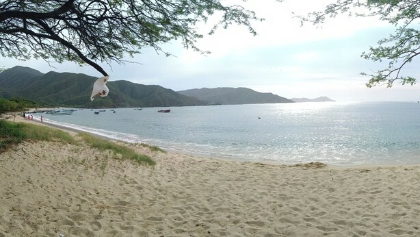 A beach with boats, a sandy shore, and hills in the background. - MAUKA OASIS Taganga  (Santa Marta)