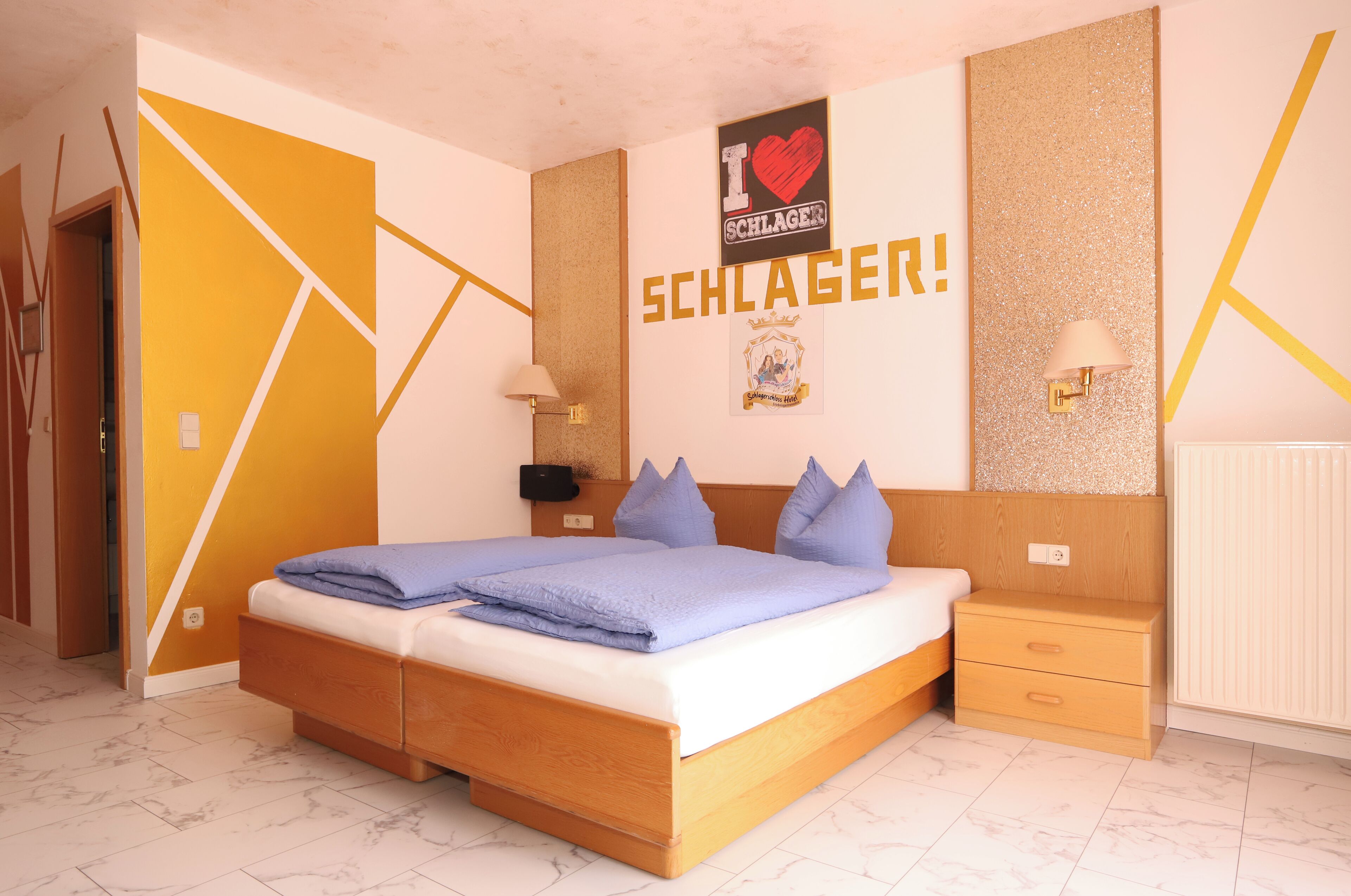 Ein Schlafzimmer mit einem Bett, Nachttischen und einer Wand mit Dekoration.