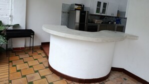 A kitchen with a white countertop, a stove, and cabinets.