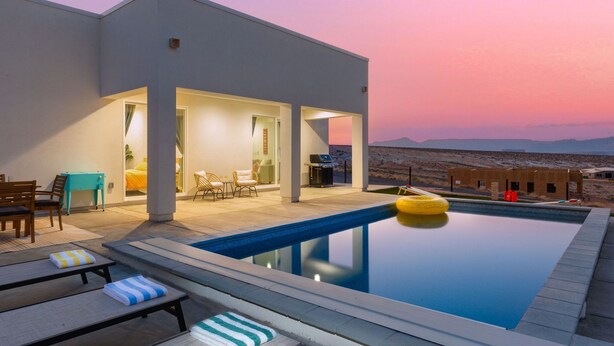 A modern outdoor pool area with lounge chairs and a view of the desert landscape. - Lakeview Oasis at Powell - Heated Pool+Lake Views+Game Room (Page)
