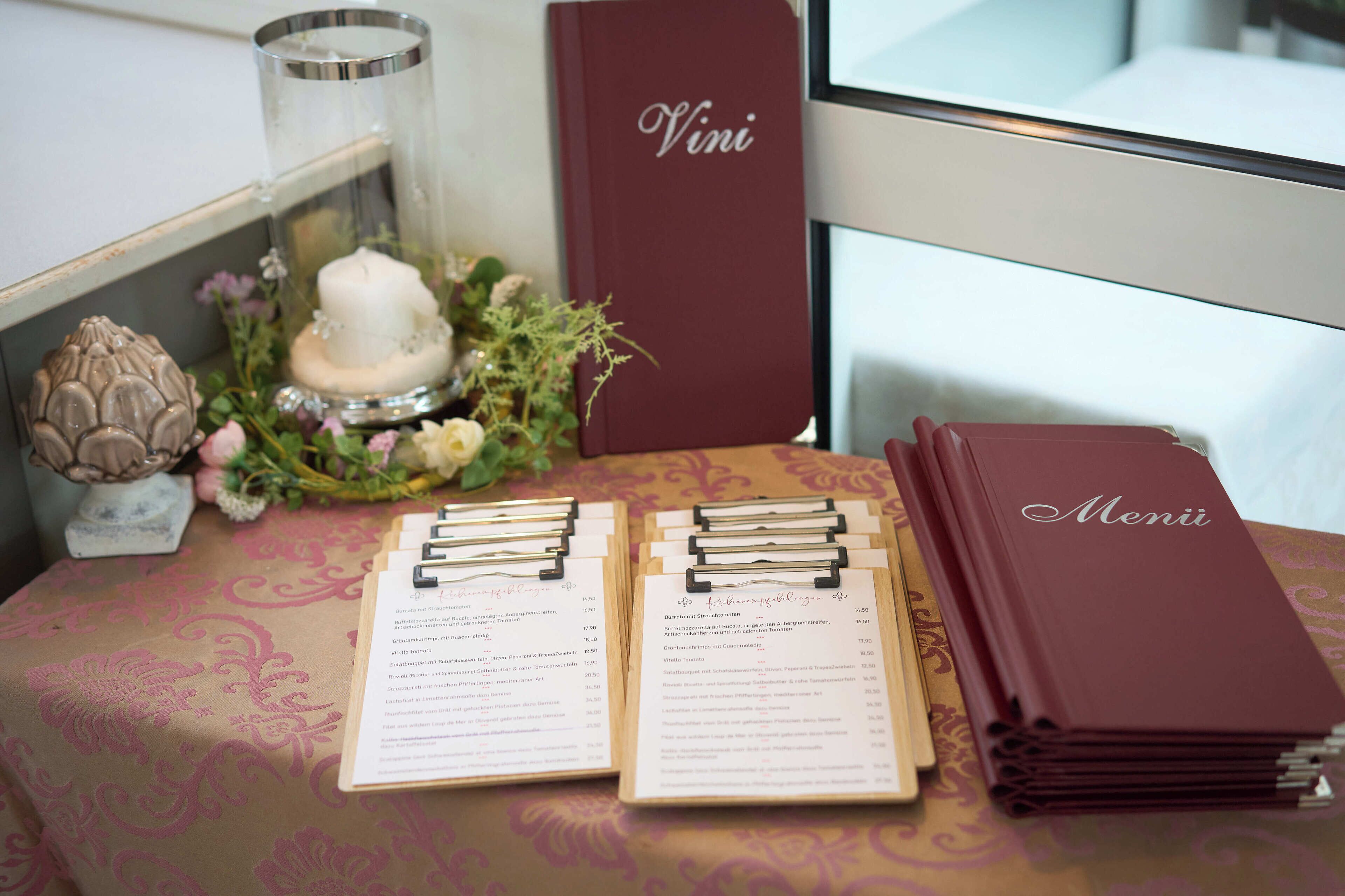 Une table avec des menus, une bougie et un élément décoratif au centre.
