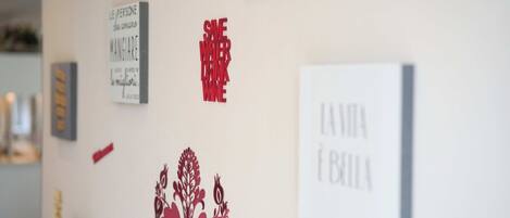 A wall with various framed artworks and a decorative floral design.