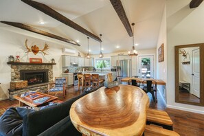 A spacious living room with a large wooden coffee table, a fireplace, and a stone accent wall.