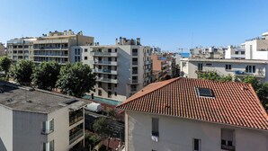 Un quartier résidentiel avec des immeubles à plusieurs étages, dont certains sont dotés de balcons, et un ciel d’un bleu éclatant.