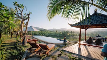 A pool area with lounge chairs, a gazebo, and a view of the surrounding landscape.
