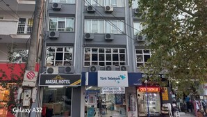 A multi-story hotel with air conditioning units, a visible sign for Masal Hotel, and a storefront for Türk Telekom. - Masal Otel (Burhaniye)