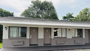 A single-story motel with a flat roof, large windows, and a small porch area.