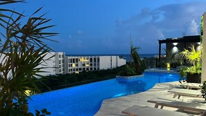 A pool area with lounge chairs and a view of a building in the background.