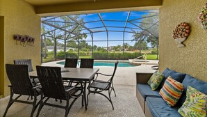 Une terrasse couverte avec une piscine, du mobilier d’extérieur et une vue sur le paysage environnant.