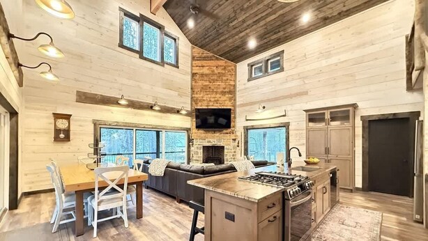 A spacious kitchen with a central island, a dining area with a wooden table and chairs, and a cozy seating area with a sofa and fireplace. - 33 MI to YNP | Wifi | Reservoir Access (Island Park)