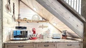 A kitchen with a microwave, mixer, toaster, and wooden cabinets. - 33 MI to YNP | Wifi | Reservoir Access (Island Park)