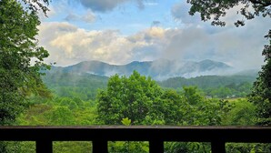 A view of lush green mountains and trees from a wooden balcony. - The Loft: Cabin Getaway w/Covered Porch & Stunning Mountain Views (Franklin)
