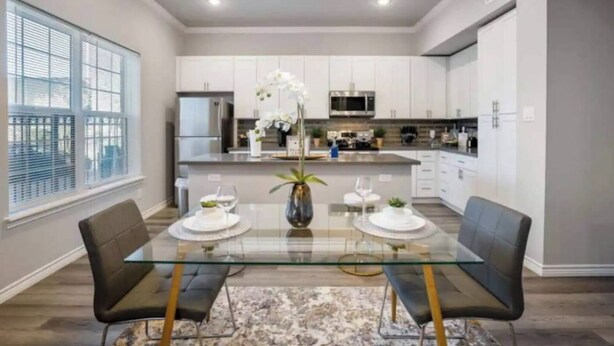 A modern kitchen with white cabinets, stainless steel appliances, and a central island. - 1BR The Raven Flats! A Hermann Park! Med Center! (Houston)