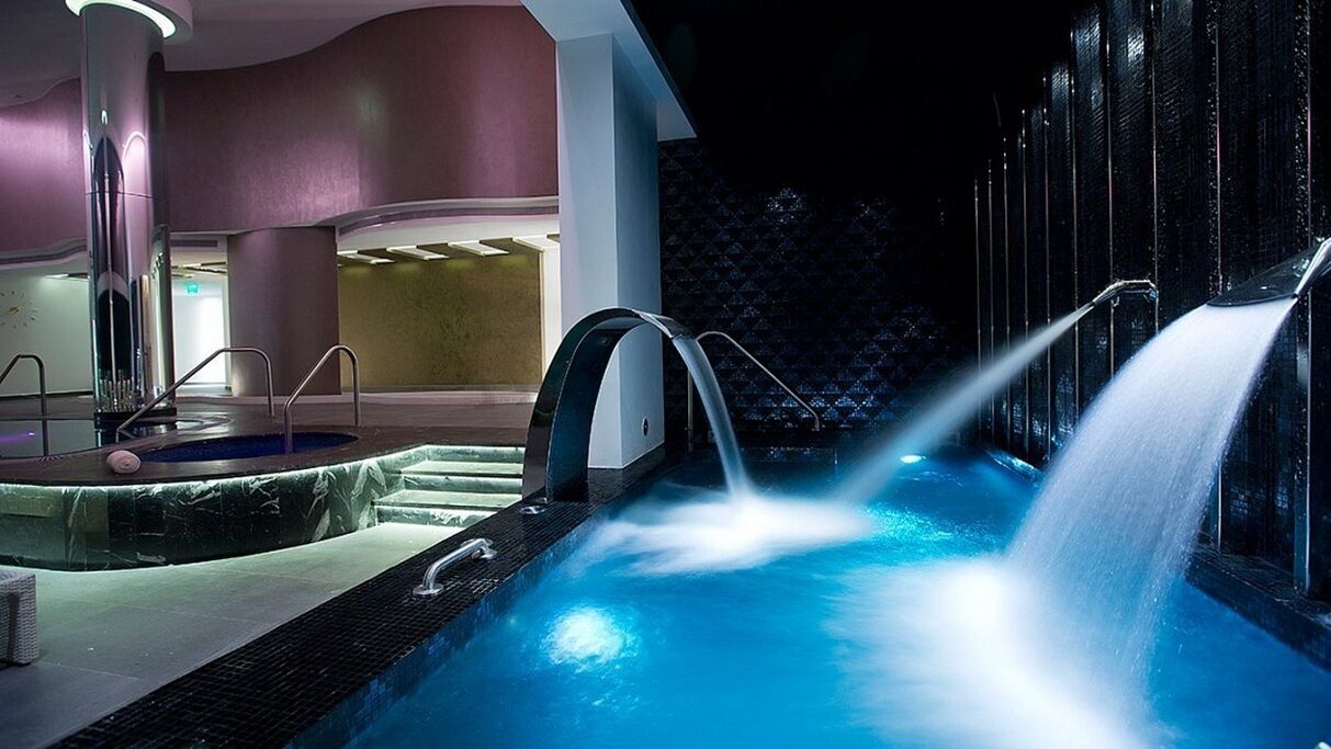 Un área de hidromasaje con piscina, una fuente y una zona de estar.