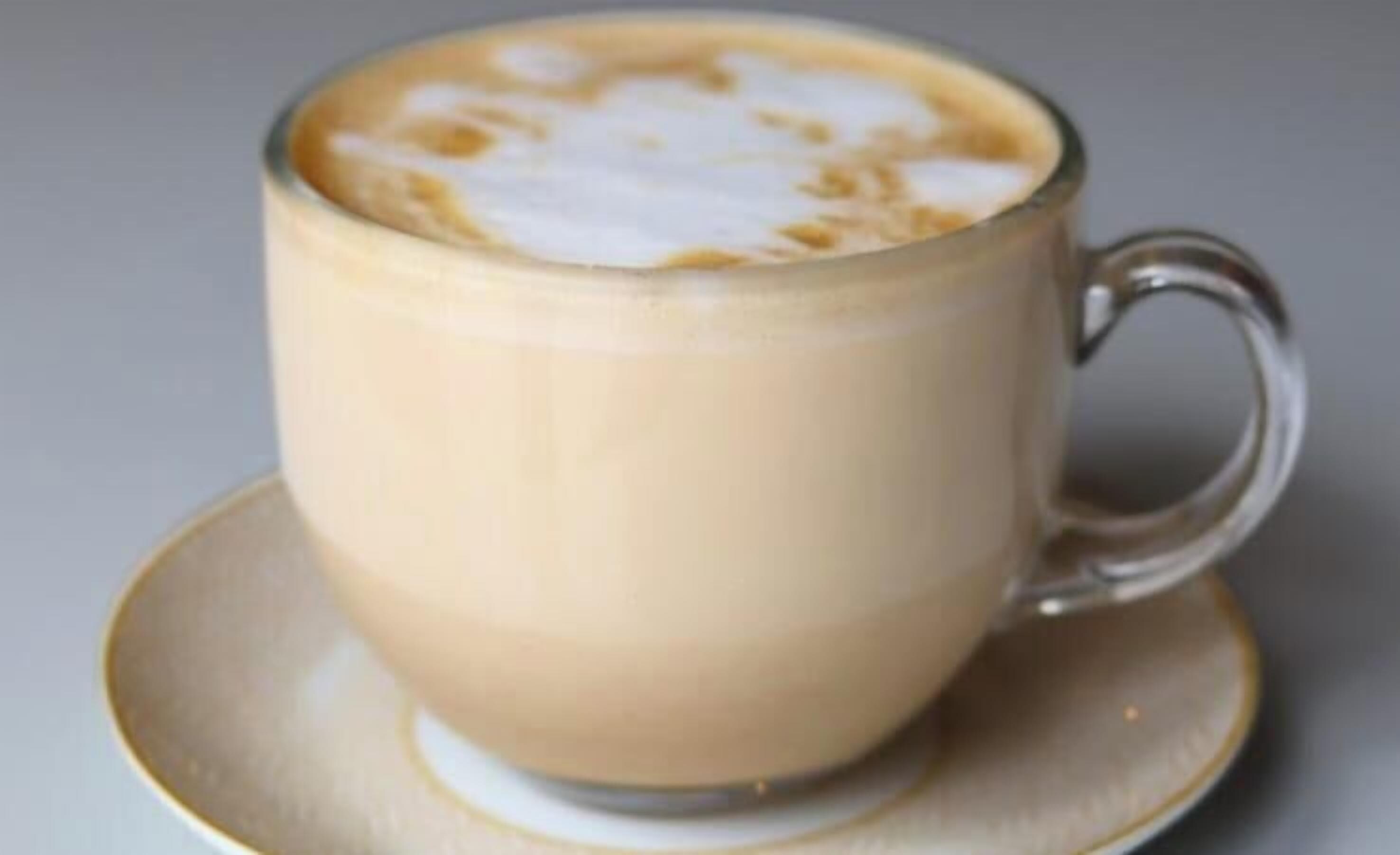 A cup of coffee with latte art on a saucer.