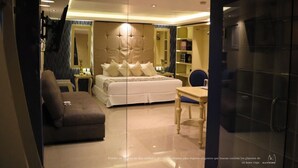 Una habitación de hotel moderna con una cama grande, un sofá, un escritorio y un espejo.