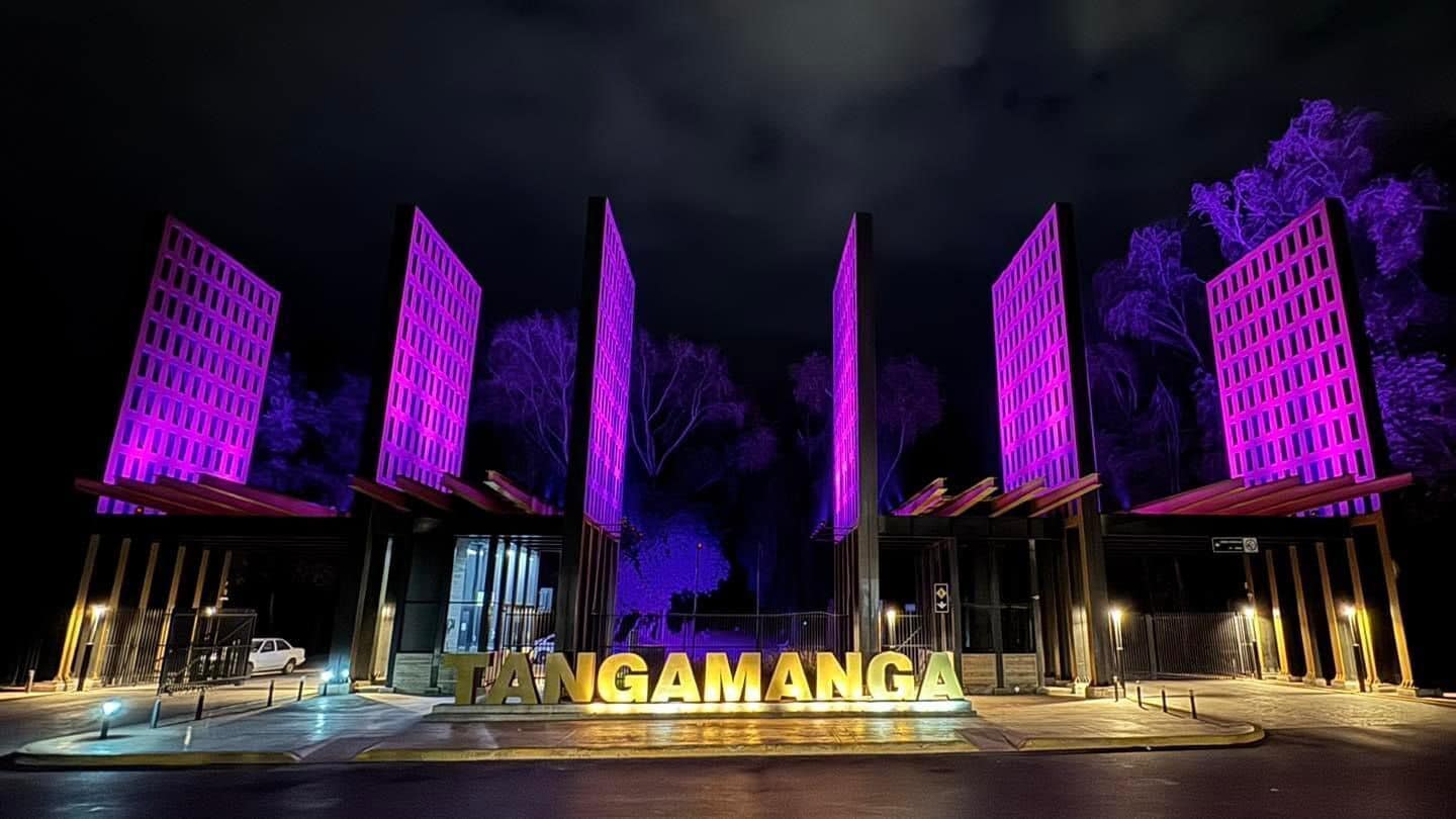 Um edifício com sinalização iluminada exibindo a palavra "TANGAMANGA" à noite.