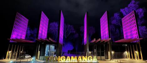 A building with illuminated signage spelling "TANGAMANGA" at night.