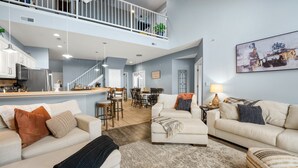 A spacious living area with a high ceiling, a dining area, and a kitchen. - Boat Slip, 3 Pools, Golf, Ozarks Amphitheater, & Amazing Lake Views at the 13mm Big Niangua (Camdenton)