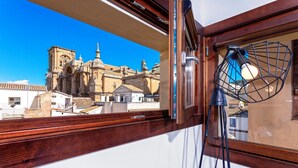 A view of a historic building through a window, with a tripod lamp inside. - Genteel Home Zacatín Granada (Granada)