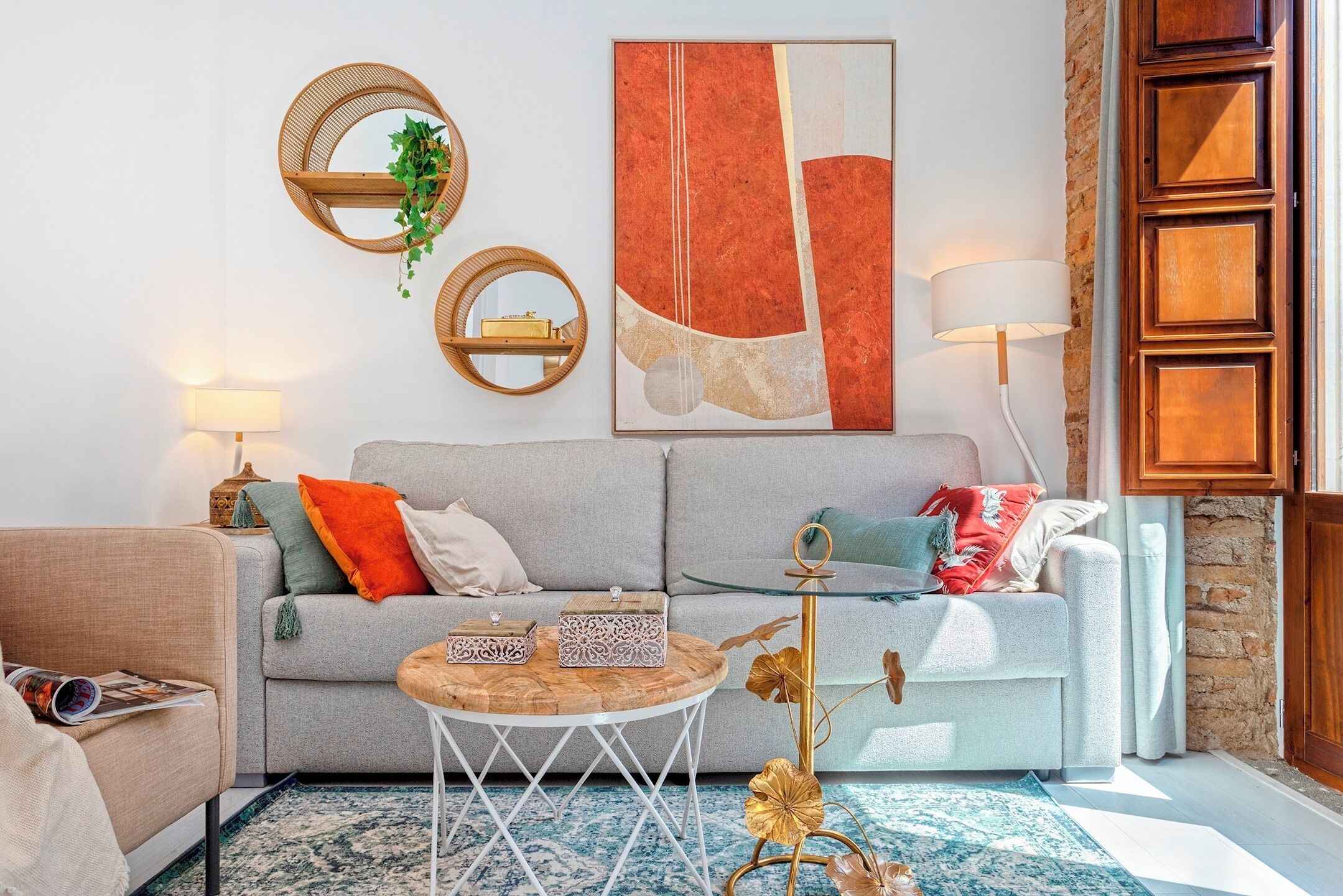 Un salon avec un canapé gris, une table basse ronde et des objets de décoration.